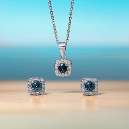 Silver necklace with a square pendant showcasing a blue gemstone surrounded by small diamonds, against a blue gradient backdrop.