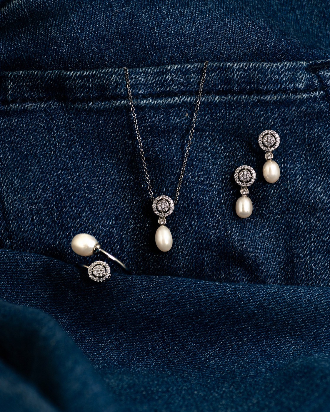 WhatsApp Image 2026-06-04 at 2.04.03 PM Pearl pendant necklace with diamond halo and matching drop earrings on dark denim backdrop