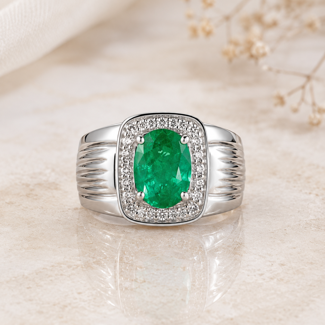 Silver ring with a large green emerald center surrounded by a diamond halo on a polished band, on a beige surface.